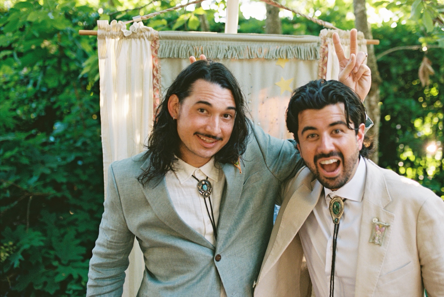 Nathan and August as adults, recreating their childhood bunny-ears pose